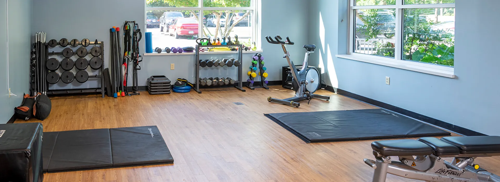 Multipurpose room with weights, cycle bike, and workout equipment.